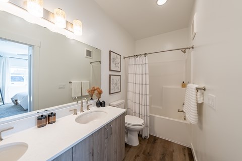 A white bathroom with a toilet, sink, and shower. at Silverbrook Apartments, Kalispell