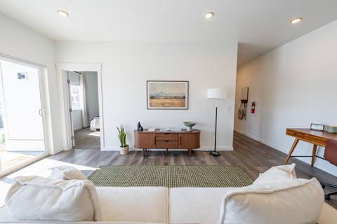 A living room with a white couch and a painting on the wall. at Silverbrook Apartments, Kalispell, Montana