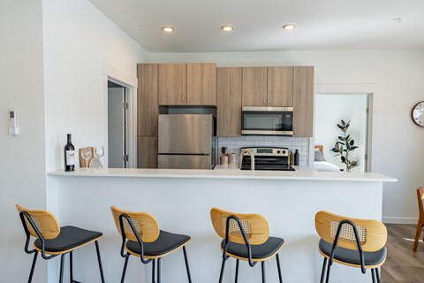 A kitchen with a white counter and four chairs. at Silverbrook Apartments, Kalispell, MT, 59901