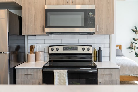 A modern kitchen with a black oven and a microwave above it. at Silverbrook Apartments, Kalispell
