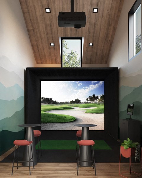 a golf simulator in a house with a large screen tv on the wall