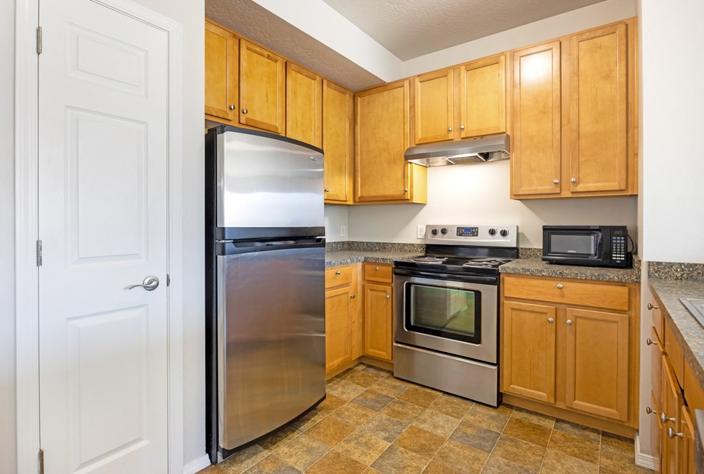 A kitchen with wooden cabinets and a stainless steel refrigerator. at Ashlyn Place, Montana