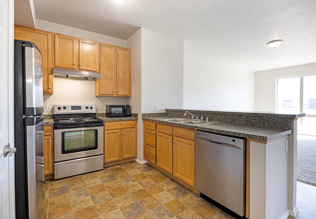 A kitchen with wooden cabinets and granite countertops. at Ashlyn Place, Missoula, MT