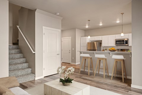 a living room with a staircase and a kitchen at Southside Townhomes, Nampa, ID, 83686