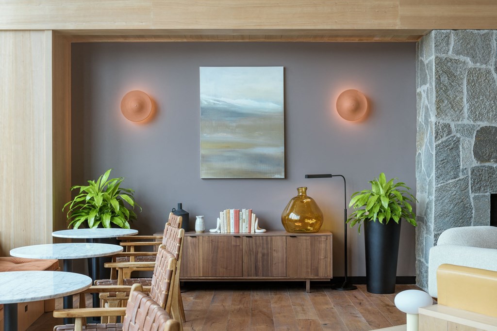 a living room with tables and chairs and a painting on the wall