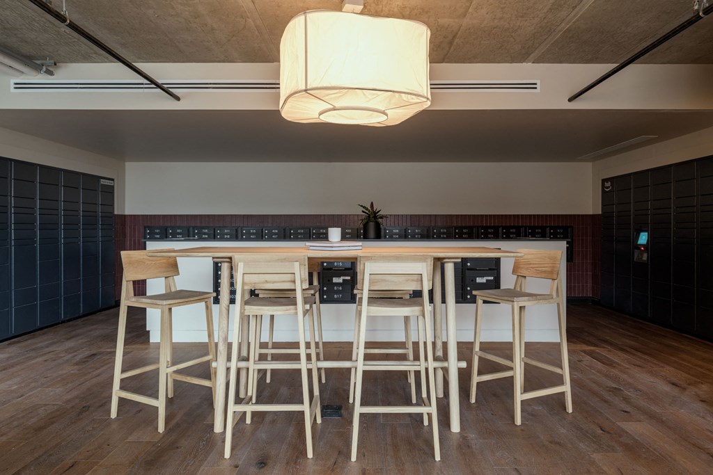 a bar with stools in a room with a table and chairs