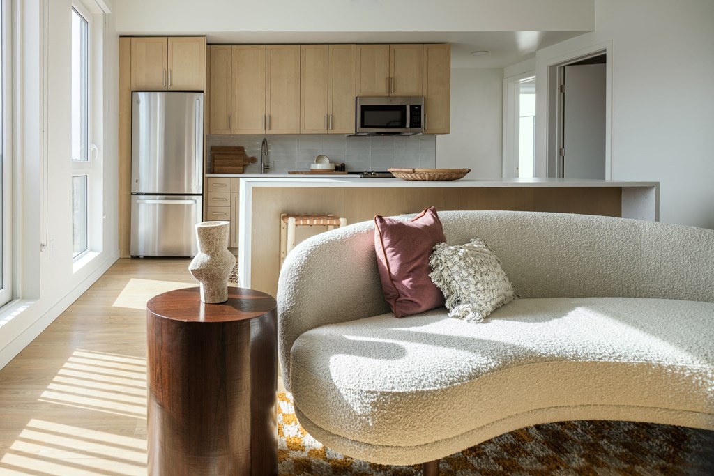 a living room with a couch and a kitchen in the background