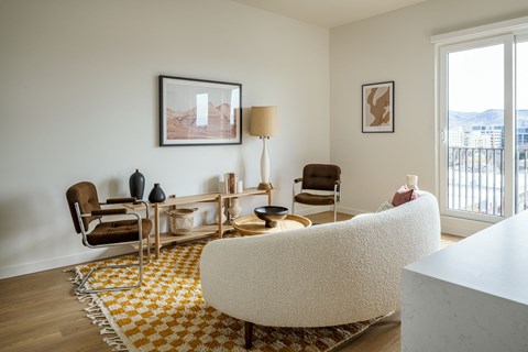a living room with white furniture and a yellow and white rug