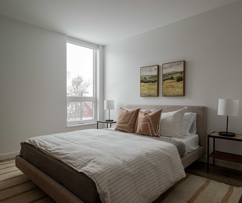a bedroom with a large bed and two paintings on the wall