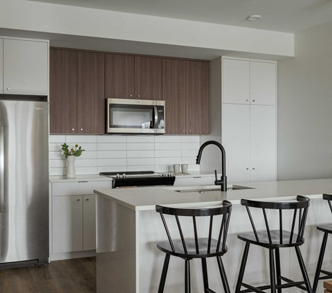 a kitchen with white counter tops and wooden cabinets