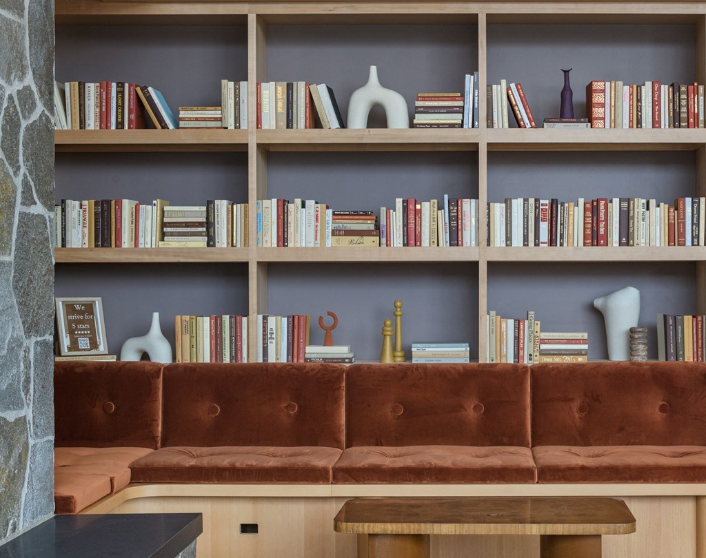 a brown couch sitting in front of a book shelf