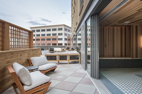 a terrace with two chairs and a table on a balcony