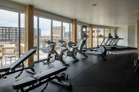 a gym with exercise bikes and a view of the city