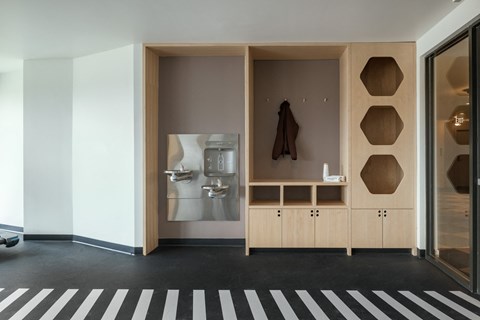 a room with a striped carpet and a cabinet with a sink and a mirror