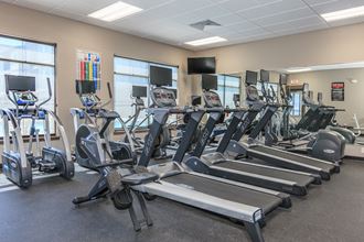 a room filled with cardio equipment and a flat screen tv at InterUrban Apartments, Billings, MT