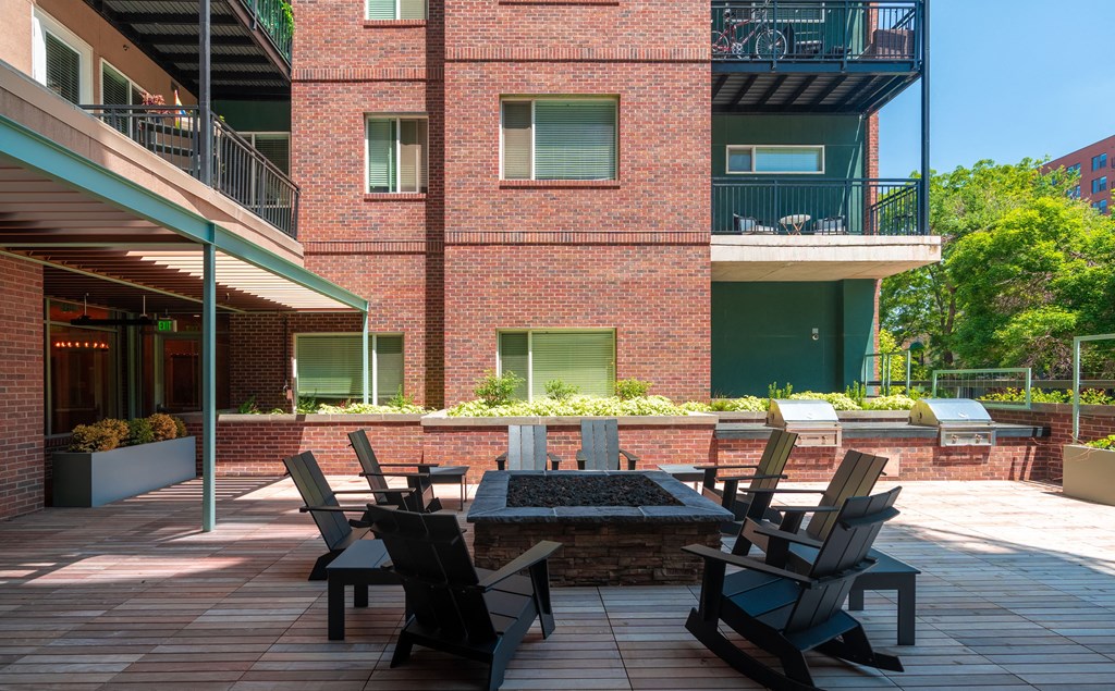 Red brick outdoor patio with chairs surrounding a fire pit at Sylvan Uptown, Colorado, 80203