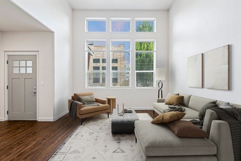 A living room with a grey couch, a brown armchair, and a grey ottoman.