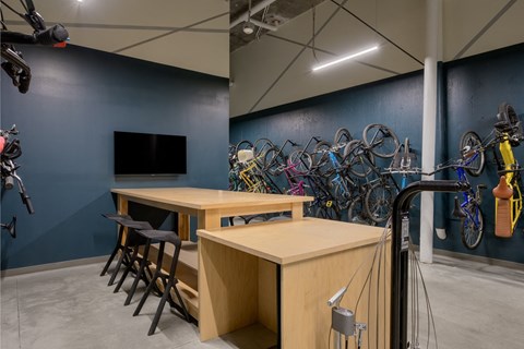 a room with tables and chairs and bicycles on the wall at The Lucy Boise Apartments, Idaho