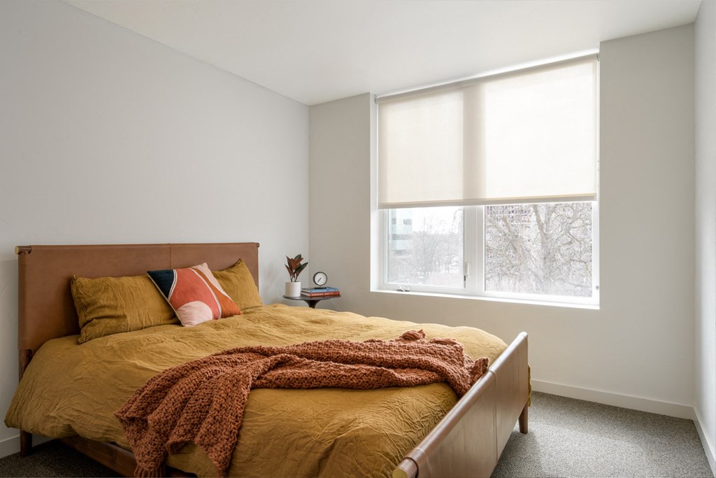 a bedroom with a bed and a large window a bedroom with a bed and a large window at The Lucy Boise Apartments, Boise, 83702