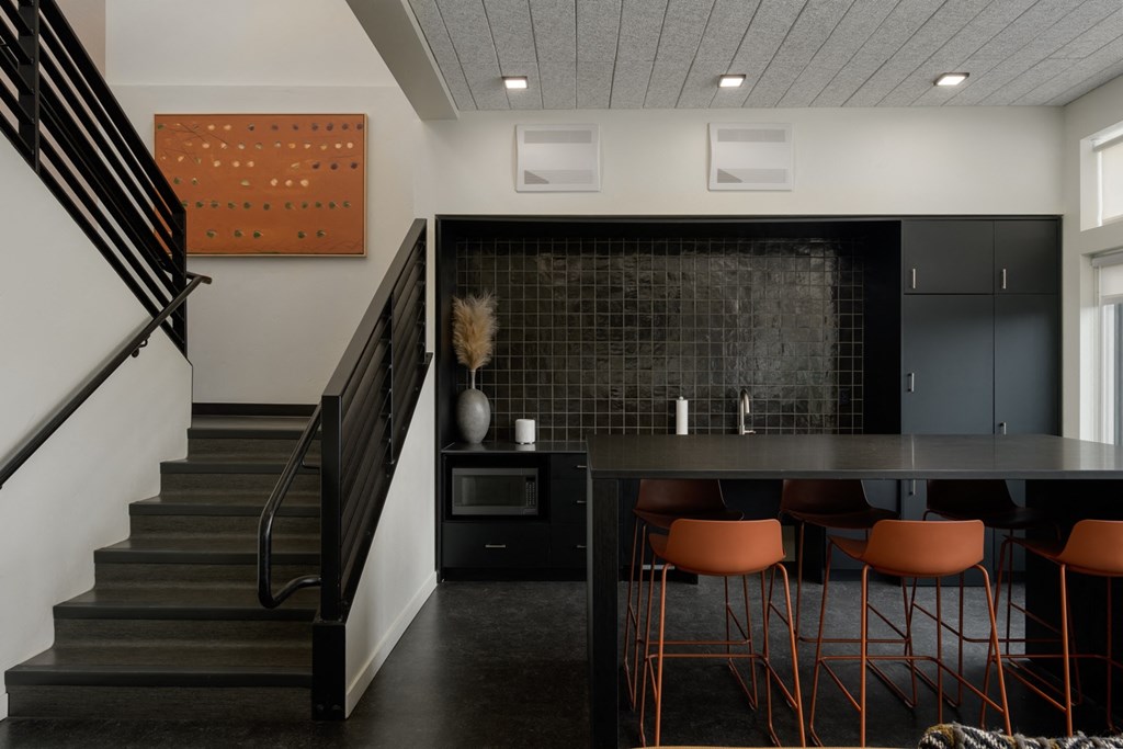 a dining room with a table and chairs and a staircase a dining room with a table and chairs and a staircase at The Lucy Boise Apartments, Boise, ID
