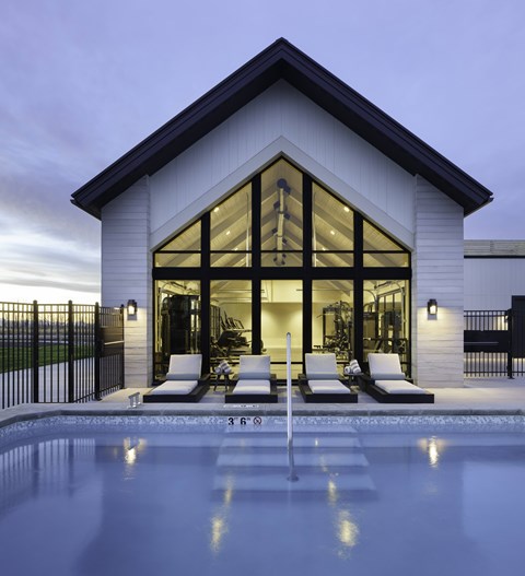 A modern house with a pool in front.