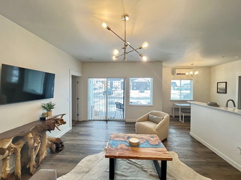 A living room with a wooden table and a television on the wall.