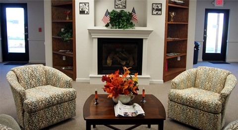 a living room with a fireplace and a table with flowers