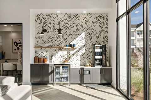 A modern kitchen with a patterned backsplash and a refrigerator with a glass door.
