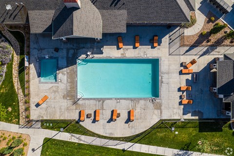 An aerial view of a swimming pool surrounded by orange lounge chairs at The Alloy at Geneva, Vineyard, 84058