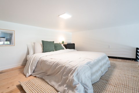 A bedroom with a large bed and a window.