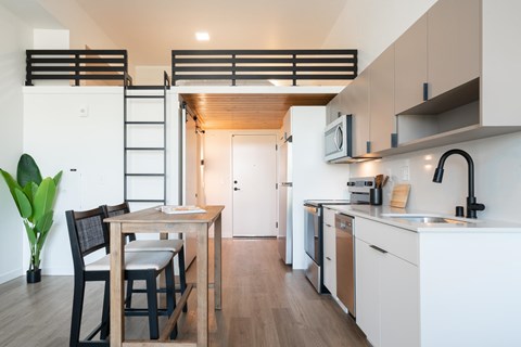 A modern kitchen with a dining table and chairs.