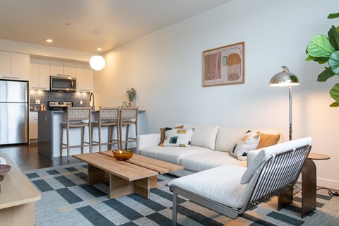 A modern living room with a white couch and a wooden coffee table.