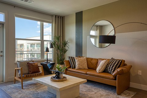A living room with a brown couch and a coffee table.