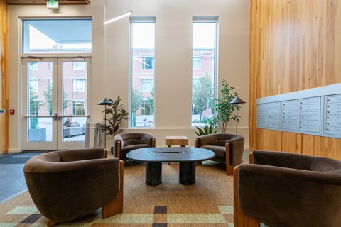 A room with brown chairs and a table in the middle.
