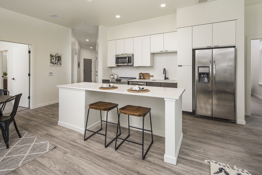 a kitchen with a large island with two stools