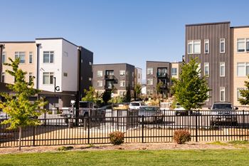a row of apartment buildings with cars parked in front of them