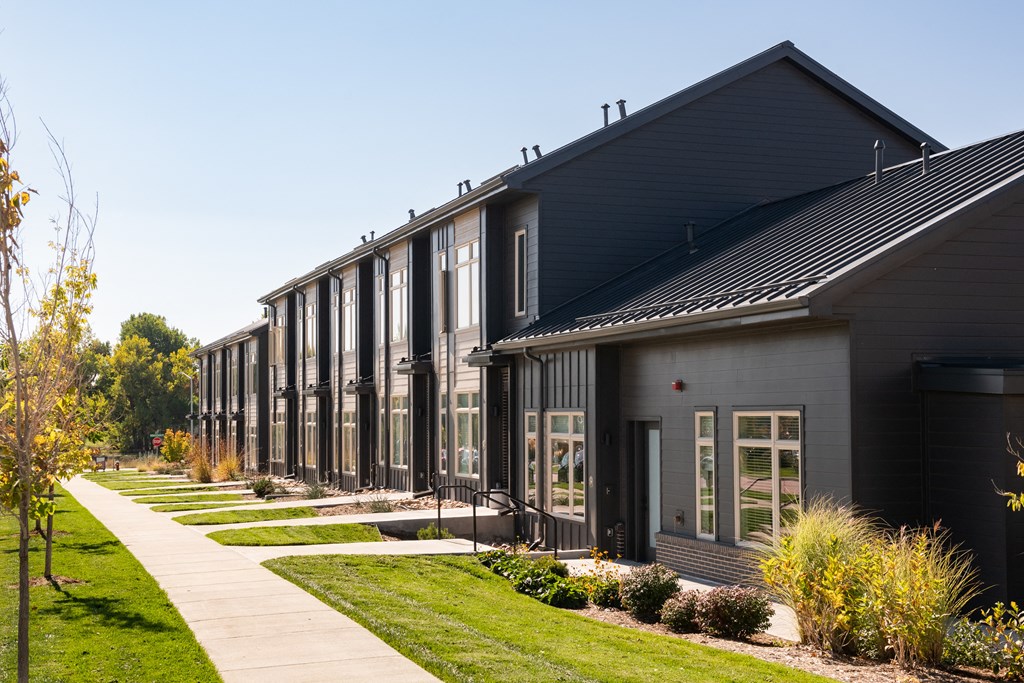 a row of houses with a sidewalk in front of them
