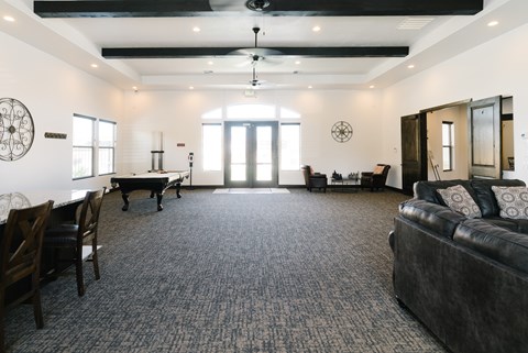 A living room with a black couch and a piano.