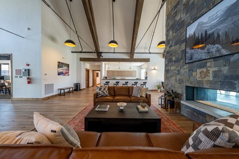 A living room with a fireplace and a stone wall. at Silverbrook Apartments, Kalispell 59901