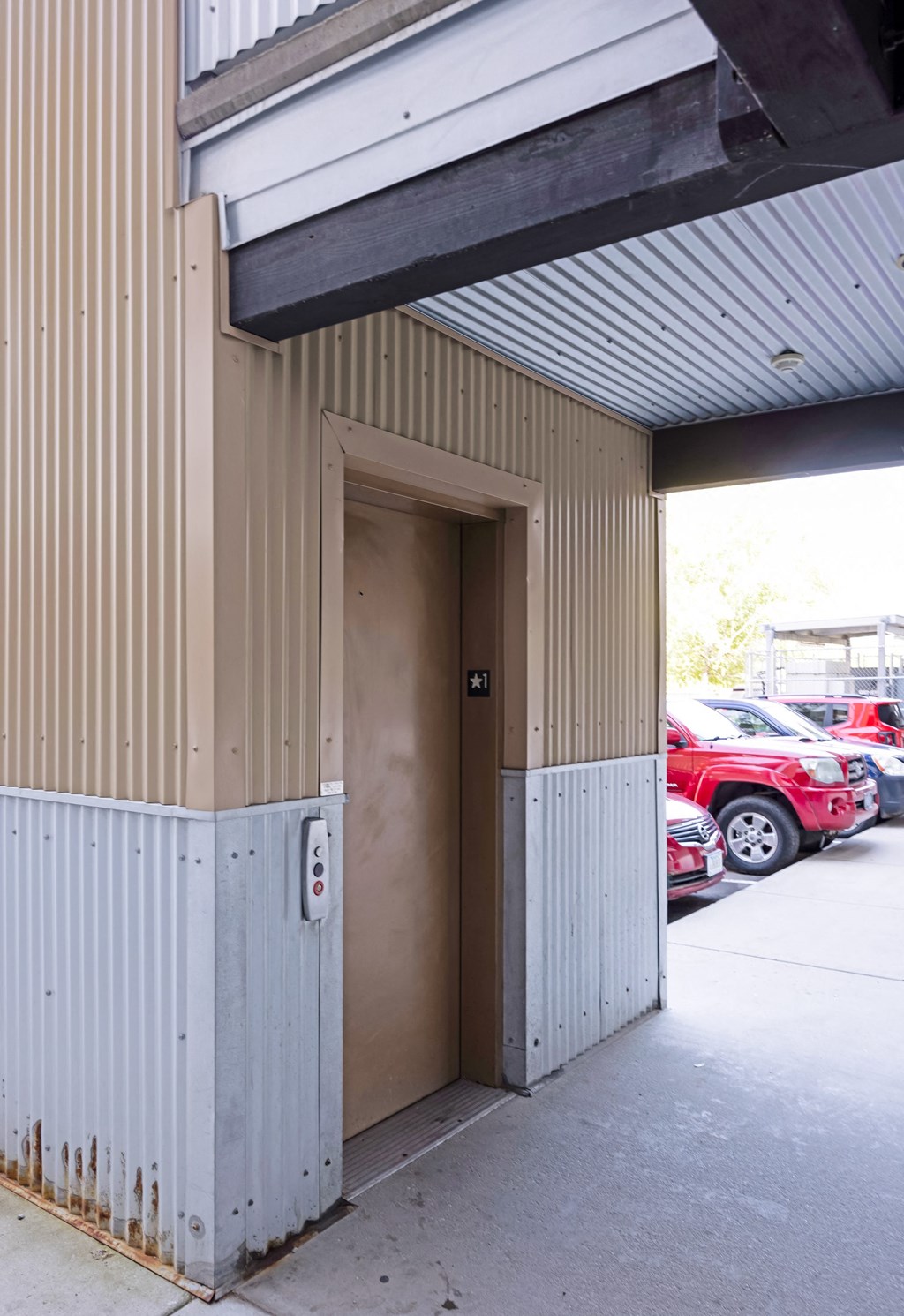 A brown door is open to a parking lot. at Ashlyn Place, Montana, 59801