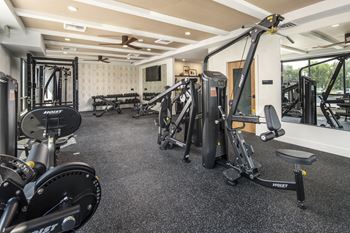 a gym with weights and other exercise equipment on the floor