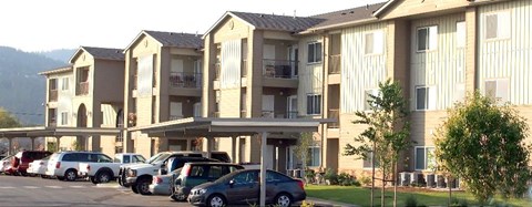 a row of cars parked in front of an apartment building