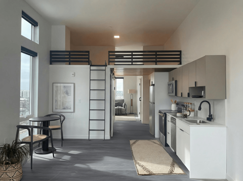 A modern kitchen with white cabinets and a black countertop.