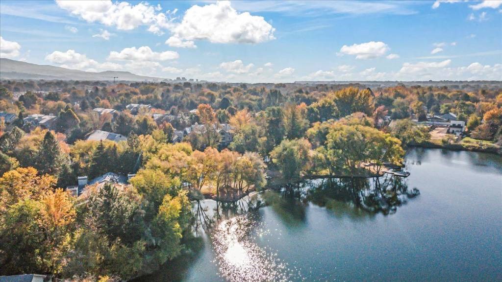 A serene landscape with a lake surrounded by trees in autumn colors.