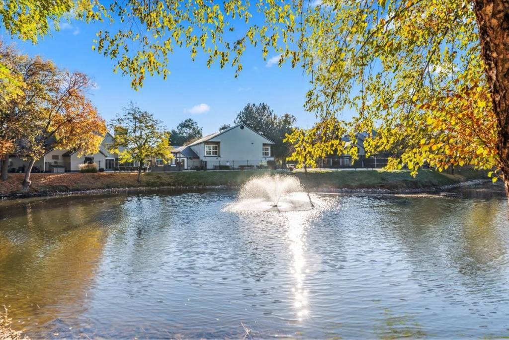A house is behind a waterfall in a pond.