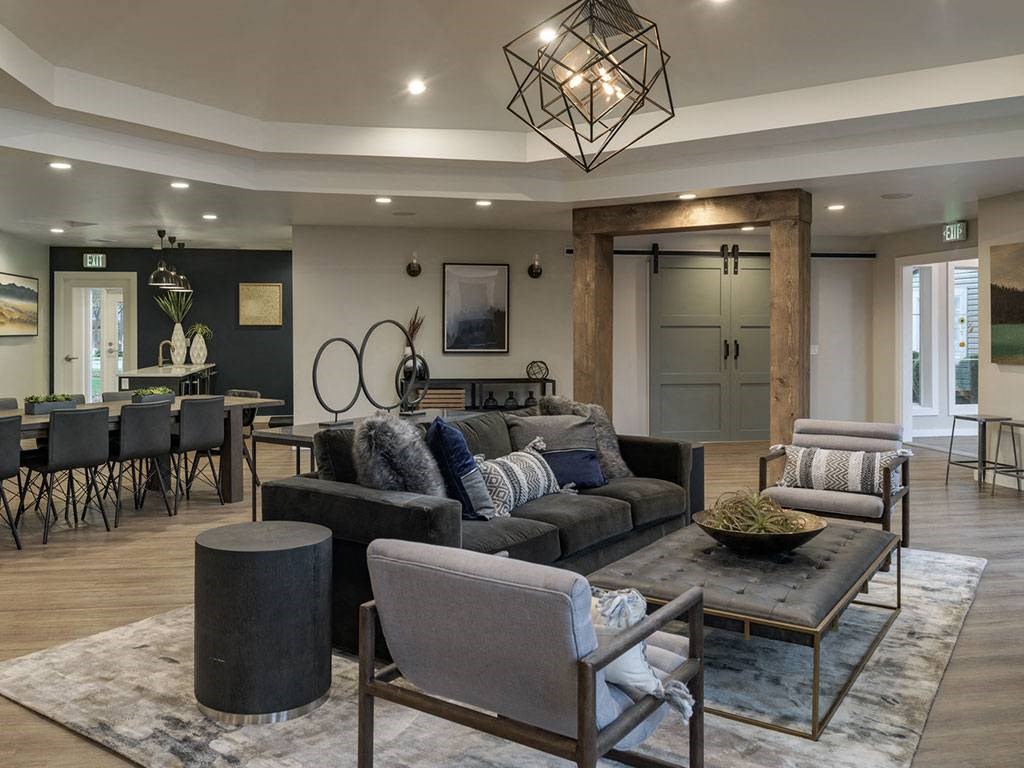 A modern living room with a grey sofa and a glass coffee table.