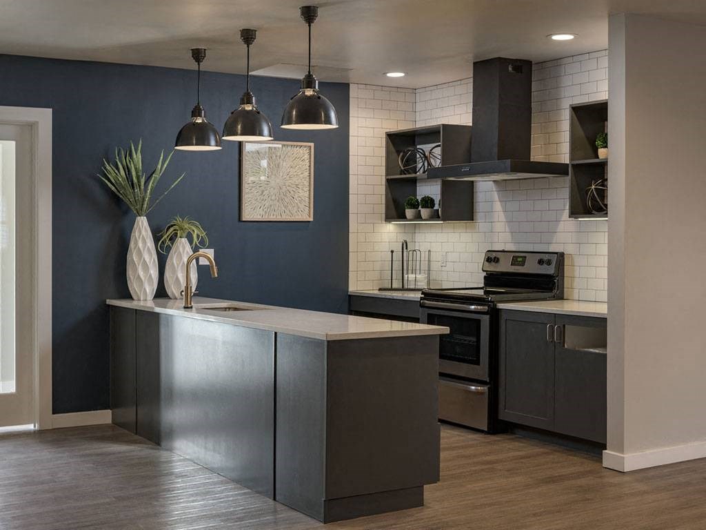 A kitchen with a dark blue wall and a wooden floor.