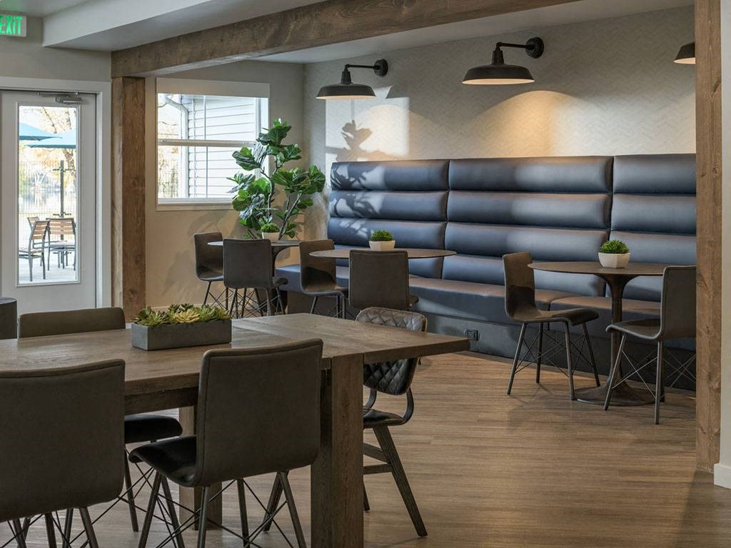 A room with a long blue couch and a table with chairs.