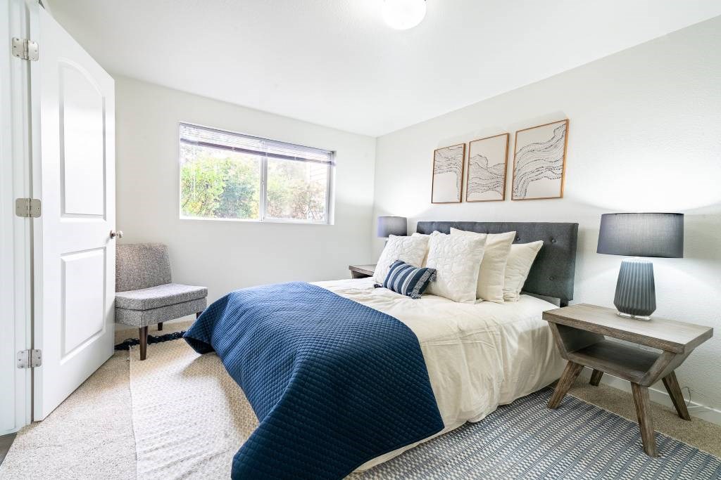 A bedroom with a large bed and a window.