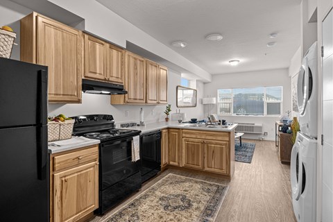 A kitchen with wooden cabinets and black appliances.